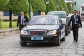 Body guards protect state automobile, which moves in the Grand Palace in Bangkok.