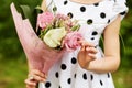 Body and hands of girl who holds bunch of flowers