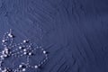 Body jewelry in the form of beads on a dark blue rough background