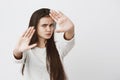 Body language. Stressed out angry beautiful teenage girl with dark long hair posing against gray studio wall, keeping Royalty Free Stock Photo