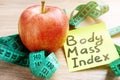 Body Mass Index BMI written on a memo stick and apple. Royalty Free Stock Photo