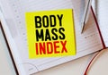 Body Mass index text on notebook with delicious green apple, measure tape, spectacle, a bottle of mineral water. Royalty Free Stock Photo