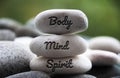 Body, Mind and Spirit words engraved on zen stones. Copy space and zen concept