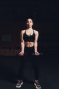 Body and mind workout in loft fitness studio. Closeup on fitness woman taking dumbbell from the floor in urban loft gym. Royalty Free Stock Photo