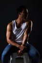 Body, muscle and sexy man on chair in studio with fitness inspiration, aesthetic and sensual fashion. Art, wellness and