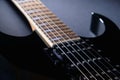 Body and neck of black electric guitar. Close up detail. On dark Royalty Free Stock Photo