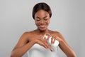 Body Nourishing. Attractive Black Female Applying Moisturising Lotion On Hand Royalty Free Stock Photo