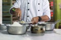 Body part of pastry chef preparing dough with flour and stainlees bowl Royalty Free Stock Photo