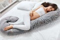 Body Pillow. Pregnant Woman Sleeping On Pregnancy Pillow On Bed