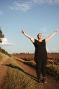 Overweight woman celebrating rising hands to sky