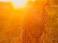 Body-positive girl poses in the autumn meadow drenched in sunlight