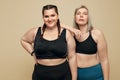Body Positive. Plus Size Models Portrait. Fat Women In Sportswear On Beige Background.