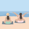 Two happy overweight women on the beach on towels by the sea