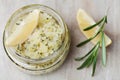 Body scrub of sea salt with lemon, rosemary and olive oil in glass jar on stone table Royalty Free Stock Photo