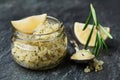 Body scrub of sea salt with lemon, rosemary and olive oil in glass jar on stone table