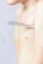 The body of a small boy, who holds a thermometer at hand and measures the body Royalty Free Stock Photo