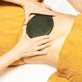 Body stone massage. Hot rock masseur. Girl at salon with doctor hands. Relax spa resort Royalty Free Stock Photo