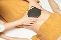 Body stone massage. Hot rock masseur. Girl at salon with doctor hands. Relax spa resort Royalty Free Stock Photo