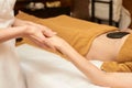 Body stone massage. Hot rock masseur. Girl at salon with doctor hands. Relax Royalty Free Stock Photo