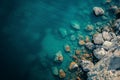 A body of water is shown with rocks and boulders surrounding it, A high-altitude image of a tranquil sea and scattered rocks, AI