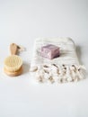 Body wooden brush, white towel and a piece of soap on a white background. Zero waste concept. Eco-friendly bath set. Copy space