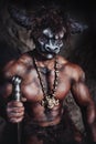 The bodyart man angry minotaur with axe in cave