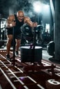 Bodybuilder athlete working out in the gym. Strong and fit man training with crossfit sled. Sport and fitness motivation