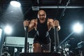 Bodybuilder athlete working out in the gym. Strong and fit man training with crossfit sled. Sport and fitness motivation