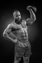 Bodybuilder with a beard lifts a heavy kettlebell. Royalty Free Stock Photo