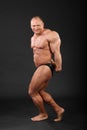 Bodybuilder demonstrates arms and legs muscles Royalty Free Stock Photo