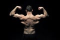 Bodybuilder with fit torso, back view. Man athlete flex arm muscles. Sportsman show biceps and triceps. Workout and