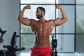 Bodybuilder Flexing Front Double Biceps Pose In Gym Royalty Free Stock Photo