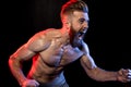 Bodybuilder gesturing and yelling isolated on black with dramatic lighting