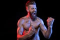 Bodybuilder gesturing and yelling isolated on black with dramatic lighting