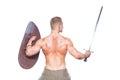 Bodybuilder man posing with a sword and shield isolated on white background. Serious shirtless man demonstrating his Royalty Free Stock Photo