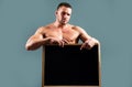 Bodybuilder man with sign advertising board. Strong athlete holding blank poster isolated on gray background. Handsome Royalty Free Stock Photo