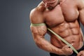 Bodybuilder measuring biceps with tape measure Royalty Free Stock Photo