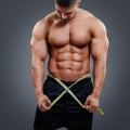 Bodybuilder measuring waist with tape measure Royalty Free Stock Photo