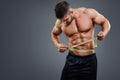 Bodybuilder measuring waist with tape measure Royalty Free Stock Photo