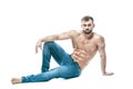 Bodybuilder posing. Beautiful sporty guy male power. Fitness muscled in blue jeans. on isolated white background. sits Royalty Free Stock Photo