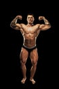 Bodybuilder posing. Beautiful sporty guy male power. Fitness muscular body. Isolated on black background Royalty Free Stock Photo