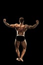 Bodybuilder posing. Beautiful sporty guy male power. Fitness muscular body. Isolated on black background Royalty Free Stock Photo