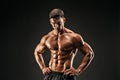 Bodybuilder posing. Fitness muscled man on dark background. Royalty Free Stock Photo