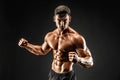 Bodybuilder posing. Fitness muscled man on dark background. Royalty Free Stock Photo