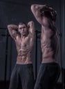 Bodybuilder posing, looking at himself, double mirror image