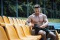 muscular athlete male preparing protein whey drink after exercising outdoor