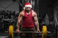 Bodybuilder in Santa Claus costume in gym