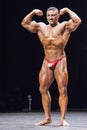 Bodybuilder shows his front double biceps pose on stage Royalty Free Stock Photo
