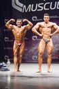 Bodybuilder shows his front double biceps pose on stage Royalty Free Stock Photo