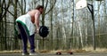 Bodybuilder is training outdoors, lifting weights in sporty area in park in spring day Royalty Free Stock Photo